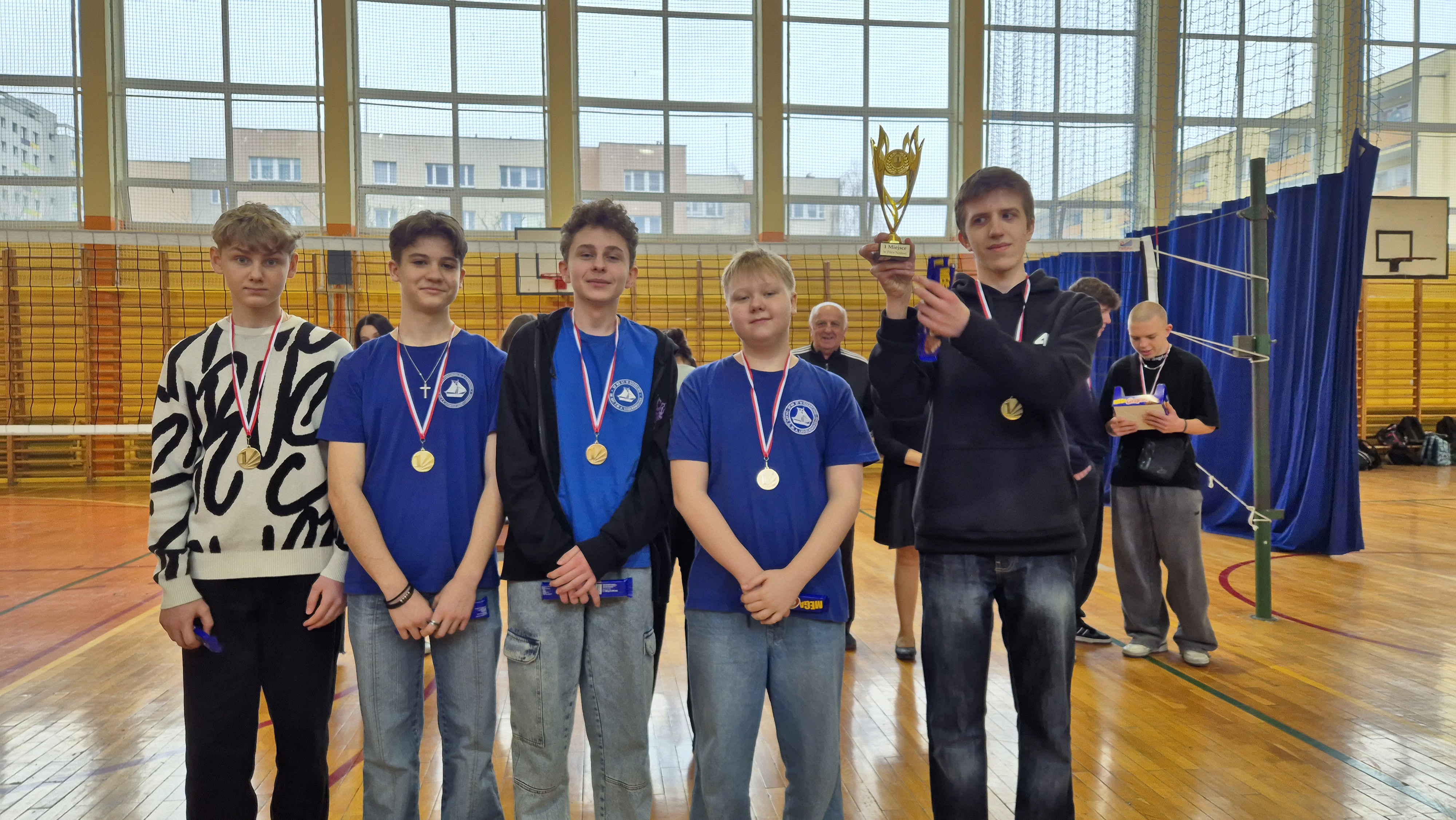 Uczniowie z Pucharem na tle hali sportowej